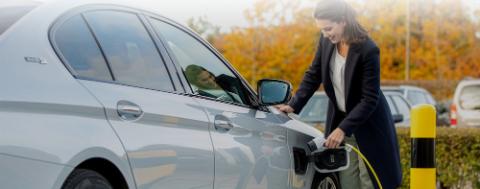 dame rechargeant son véhicule électrique