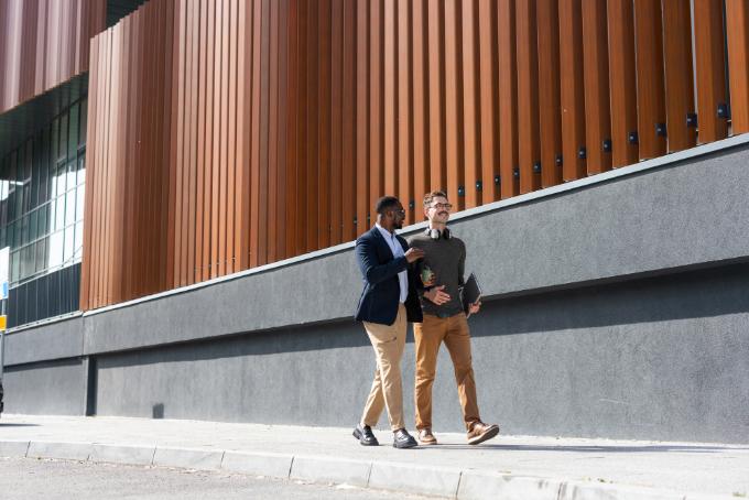 Professionnels échangeant devant un bâtiment d’entreprise 