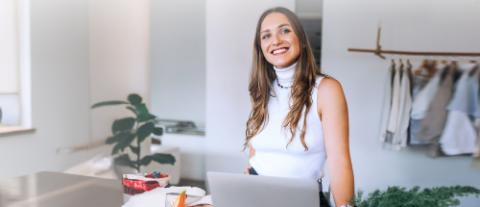 femme souriante devant une tringle de vetements