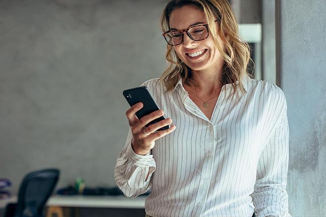 dame souriante avec un smartphone en main