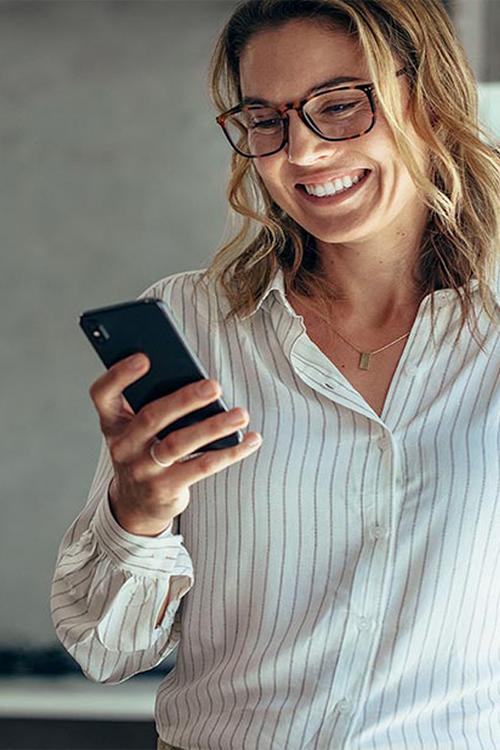 dame souriante avec un smartphone en main