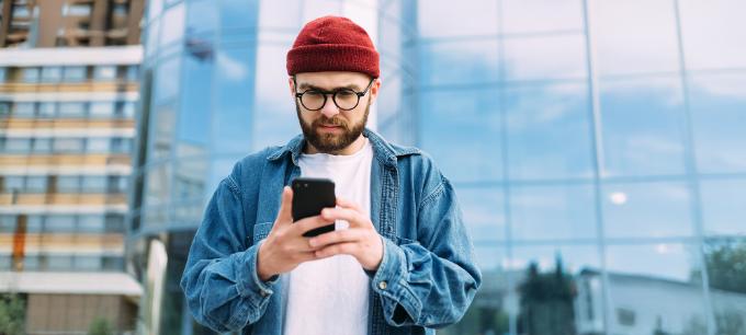 homme portant un bonnet rouge et utilisant un smartphone