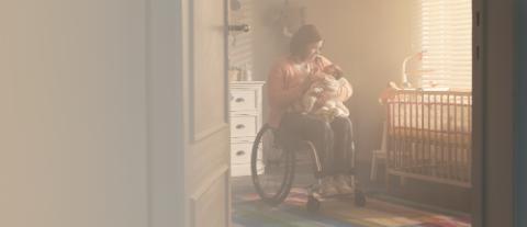 dame en chaise roulante portant un bébé
