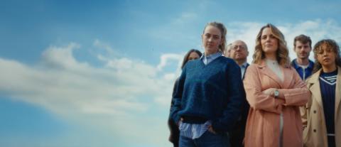 Groupe de personnes devant un ciel bleu