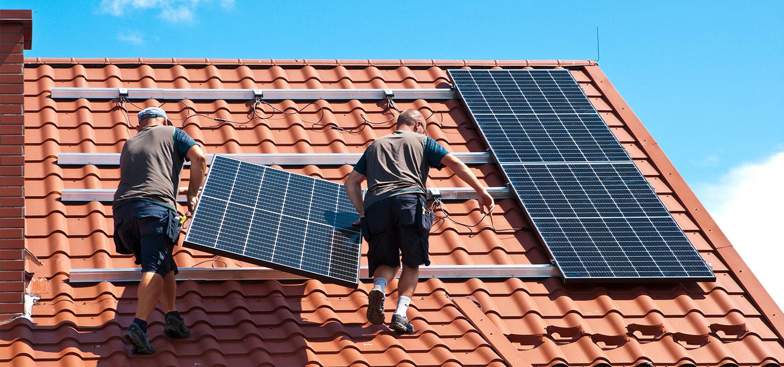 Installateurs plaçant des panneaux solaires sur un toit