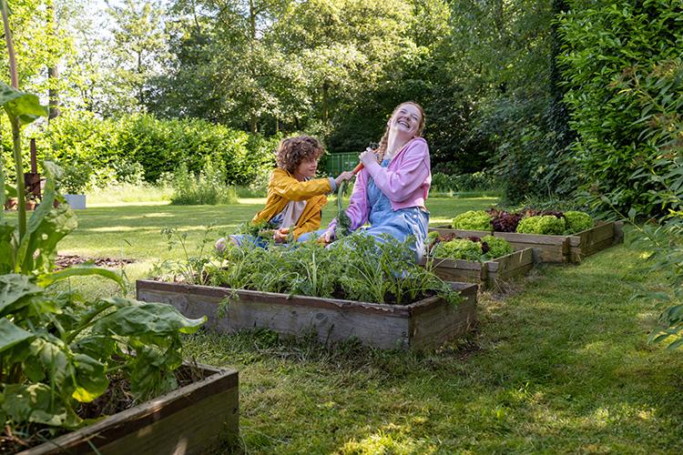 une mère avec son enfant dans le potager