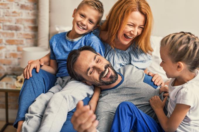 Happy family lying down on bed at home Ouvrir un compte pour votre enfant