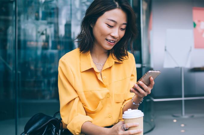 Jeune dame investissant sa monnaie via un smartphone