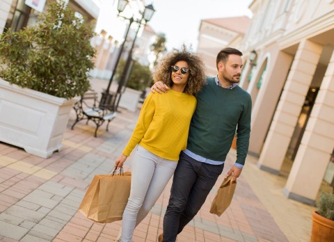 Beautiful young multiethnic couple enjoying in shopping, having fun in the city