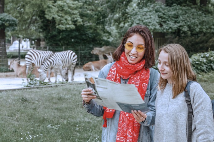 2 vriendinnen staan voor zebra&#39;s in de zoo