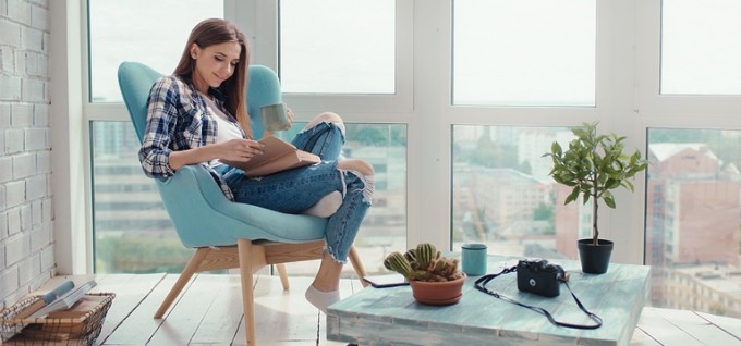 Femme fauteuil livre tasse