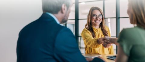femmes se serrant la main dans un bureau