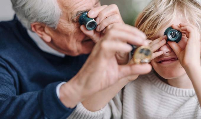 Un grand-père regarde des pièces de monnaie avec son petit-fils